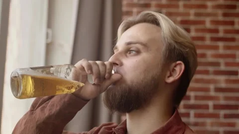 A modern guy with a beard drinks beer from his throat. Stylish guy with a beard Stock Footage 135613949