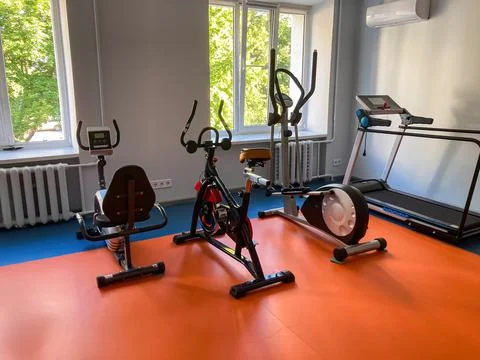 Modern gym setting with exercise equipment weightlifting bench, rowing mach.. Stock Photos