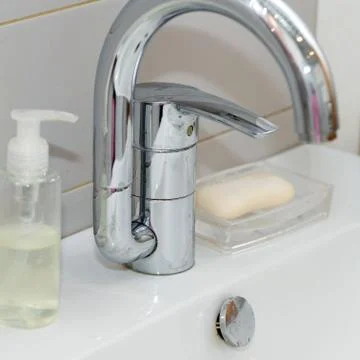 Modern hand wash basin. Solid tabletop surface and gray tile wall. Stock Photos