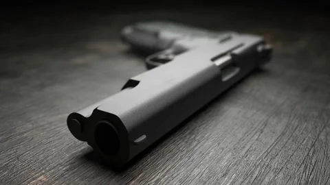 Modern handgun placed on a grey table turns around against black background Stock-Footage 160463596