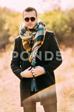 Modern handsome man in the autumn park. Seasonal fashion. Autumn style. Stock Photos