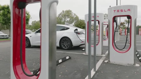 Modern, high-end vehicles connected with cables to EV stations Stock-Footage 233295420