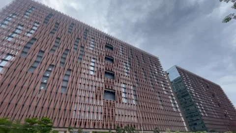 Modern High Rise Building Under Dramatic Cloudy Sky with Trees Video stock 337722244