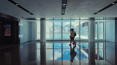 A modern high-rise lobby with panoramic cityscape view, featuring a polished Stock Footage 338310987