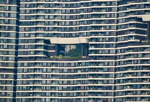 Modern High Rise with Midsection Green Space and Grid Facade Stock Photos