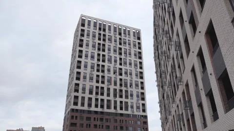 Modern high-rise residential complex with geometric facade Stock Footage 303108458