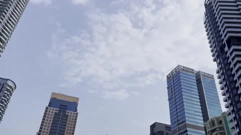 Modern high-rise skyline under cloudy sky with glass balconies, striped Stock Footage 345437427