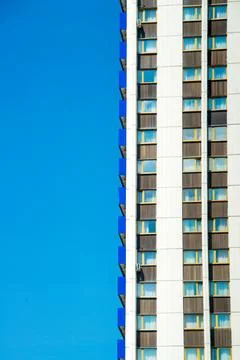 Modern High Rise Skyscraper Facade and Windows Against Clear Vibrant Blue S.. Stock Photos
