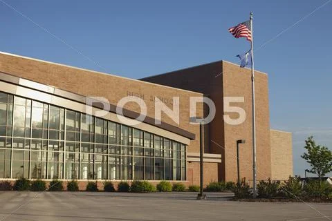 Modern high school with american and minnesota flags flying Stock Photos