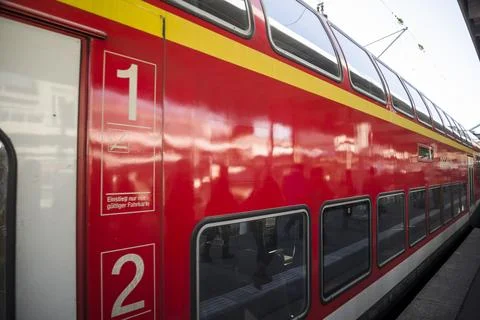 Modern high speed red commuter train at the railway station Stock Photos