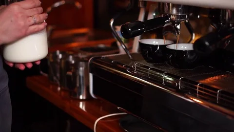 Modern high technology espresso machine pouring coffee into small black cups in Stock Footage 105453531