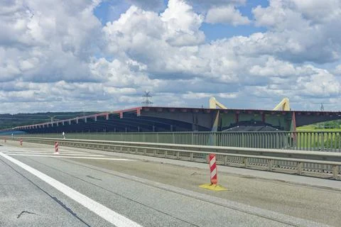 Modern highway bridge under construction with safety barriers and cloudy sky Stock Photos