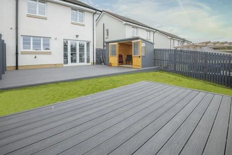 Modern home features gray deck and green lawn Stock Photos