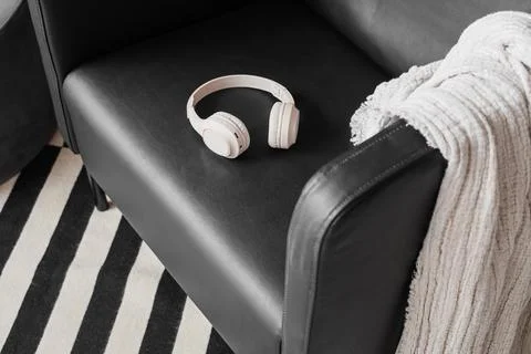 Modern home interior design with wireless headphones on black leather armchai Stock Photos