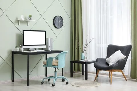 Modern home office with computer and cozy seating area Stock Photos