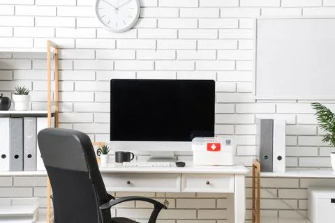 Modern home office desk with computer and first aid kit Stock Photos