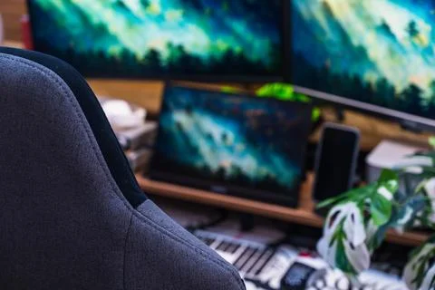Modern Home Office Desk with Triple Monitors and LED Lighting Setup Stock Photos
