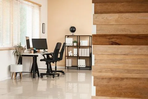 Modern home office interior with two computer monitors on a desk and a wooden Stock Photos