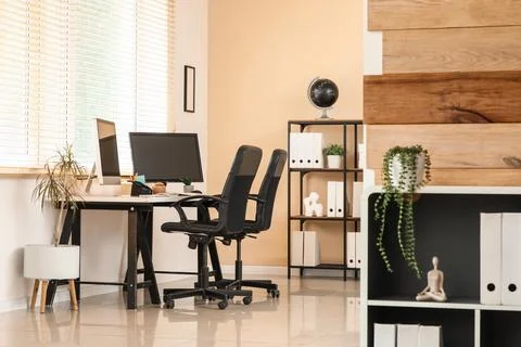 Modern home office interior with two computer monitors on a desk and ergonomi Stock Photos