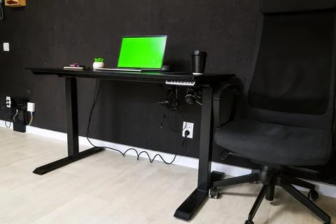 Modern home office setup with adjustable standing desk and ergonomic chair Foto stock