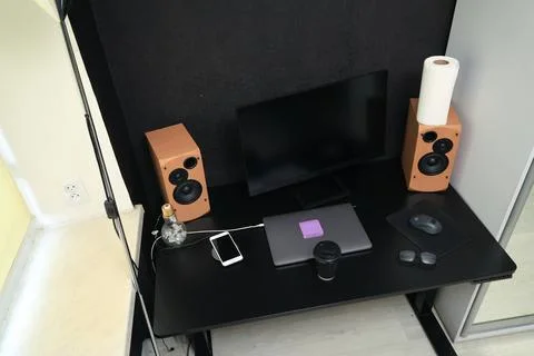 Modern home office setup with computer, laptop, speakers, and coffee Stock Photos