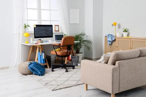 Modern home office setup with computer and cozy living room Stock Photos