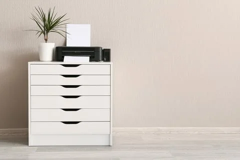 Modern home office setup with printer, plant, and white drawer cabinet for ef Stock Photos