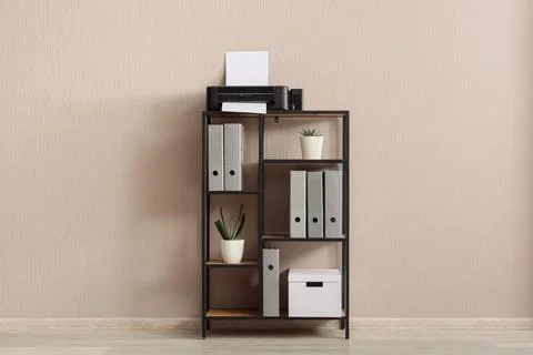 Modern home office shelf with printer, files, and potted plants against a neu Stock Photos