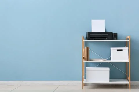 Modern home office shelf with printer, books, and storage boxes against a lig 写真素材