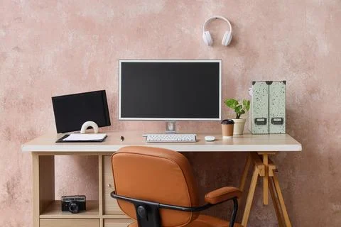Modern home office workspace with computer monitor, desk, chair, and minimali Stock Photos
