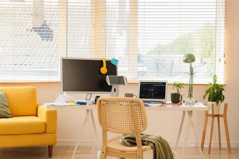 Modern home office workspace with multiple screens and natural light for remo Stock Photos