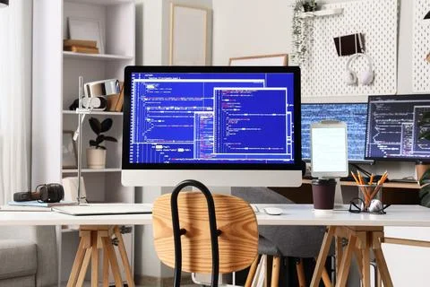 Modern home office workspace with multiple computer screens displaying progra 写真素材