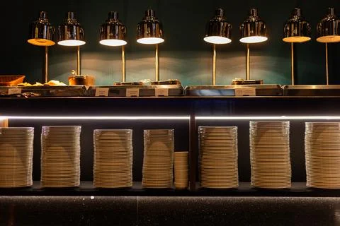Modern hotel buffet with stacks of white plates, serving dishes and warm fo.. Fotos Stock