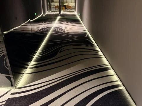 Modern Hotel Corridor with Abstract Patterned Carpet and Ambient Lighting 스톡 사진