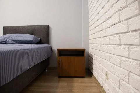 Modern hotel room view of the bedside table and bed in a hotel room Stock Photos