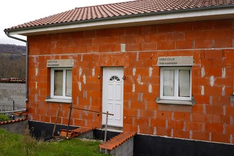 Modern house construction with red ceramic brick walls white windows and door Stock Photos