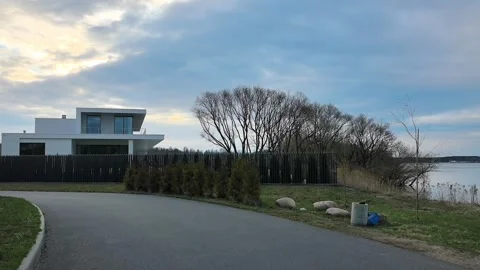 Modern house near a river surrounded by trees and greenery Stock Footage 340187155