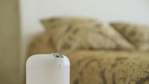 Modern humidifier, aroma oil diffuser at home interior. Comfort in the bedroom Stock Footage 197683126