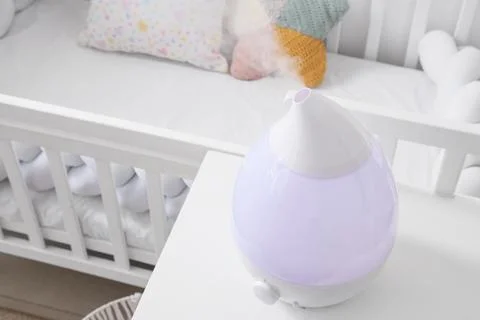 Modern humidifier on bedside table in childrens bedroom Stock Photos
