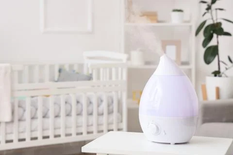 Modern humidifier on bedside table in childrens bedroom Stock Photos
