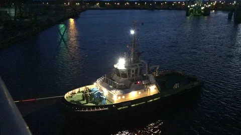 Modern illuminated harbor tug pulls ship to port at night Stock Footage 114262831