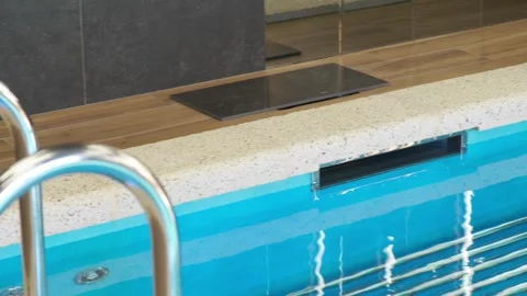 Modern indoor overflow pool with water intake system. Clear blue water, stone fi Stock Footage 312076953