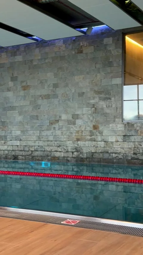 Modern indoor swimming pool inside a luxury spa resort, showcasing clean blue Stock Footage 345827453