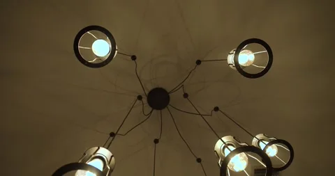A modern industrial ceiling light fixture with glowing exposed bulbs. Slow Stock Footage 342301200