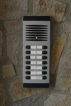 Modern intercom on concrete wall with stone fragments. Security system Foto stock