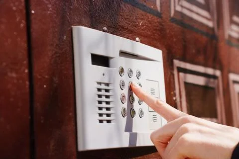 Modern intercom keypad on residential building entrance wall Stock Photos