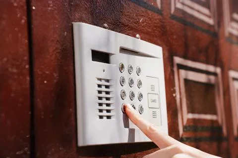 Modern intercom keypad on residential building entrance wall Stock Photos