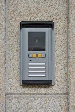 Modern intercom mounted on textured stone wall Foto stock