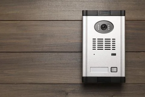 Modern intercom system with camera on wooden background, top view. Space for  Stock Photos