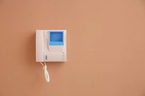 Modern intercom system with handset on beige wall, space for text Stock Photos